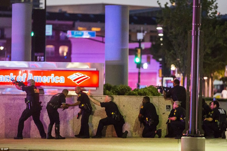 This photograph depicts Dallas police taking cover from the claimed snipers. Is this a realistic defensive cover position against a sniper in an elevated position? Highly reminscient of the ridiculous police response to the Ottawa hoax. 