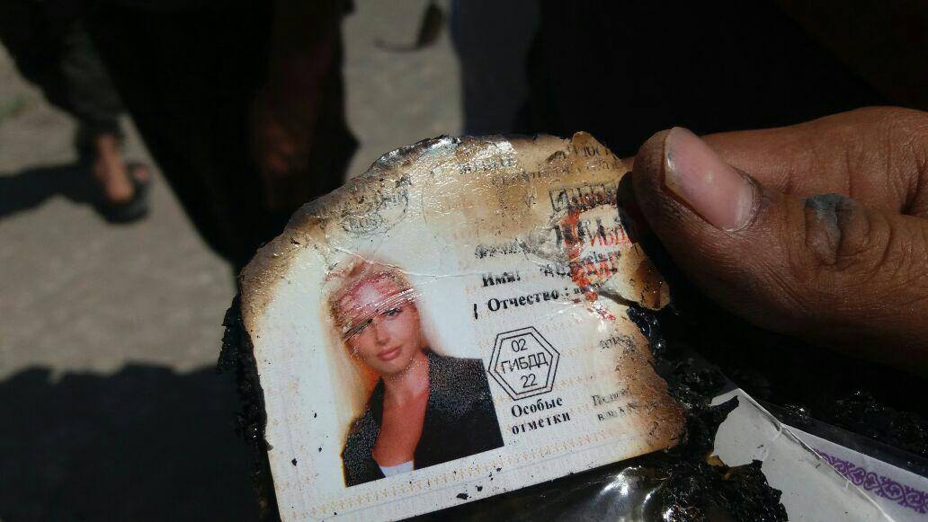 Insurgents diplay an ID card they retriieved from the wreckage of the downed Helicopter. 
