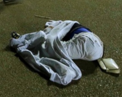 This is supposed to be a dead body. This is a blue circular object wrapped in a sheet.with a purse placed beside it. No body and no blood presented as a dead body makes it perfectly clear the event was completely staged. A real attack would not require blue circular objects wrapped in sheets to be presented as one of the victims. 