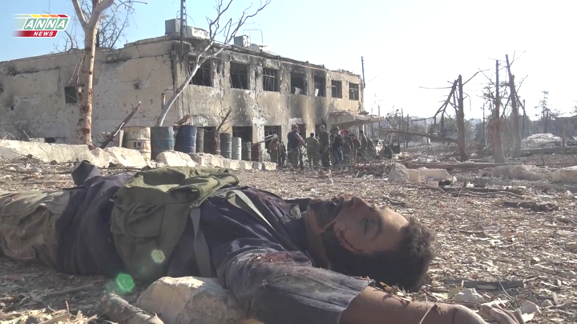 A somewhat callous but perfectly symbolic image captured by the ANNA News photographer after the insurgent positions inside the military colleges of south west Aleppo collpased on September 4th. A dead insurgent fighter lies in the foreground, behind him the Syrian Army and the shattered landscape. 